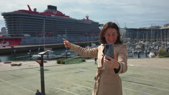 The Girl is Talking on the Phone in Front of a Cruise Ship