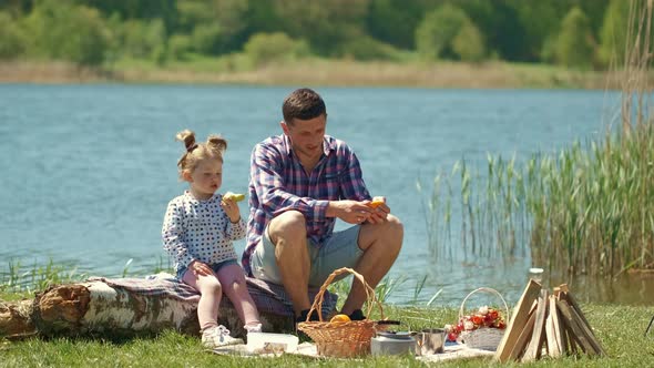 Father with Little Daughter on a Picnic Near the River