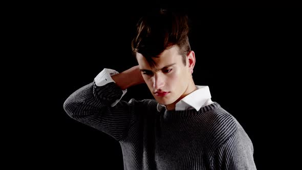 Androgynous man posing against black background