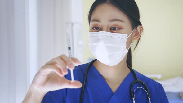 Close Up Female Asian Nurse Doctor Holding a Vaccine Injection Needle Ready for Vaccination at Work