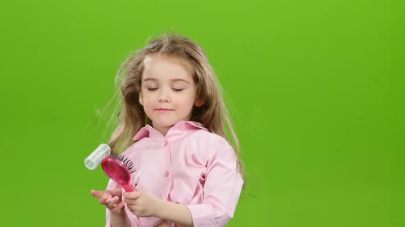 Child Removes the Curlers and Starts Combing His Long Hair. Green Screen