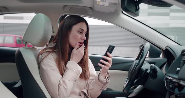 Scared Young Woman Looking in Smartphone with Big Eyes Shocked Expression Closing Mouth Zipping Lips