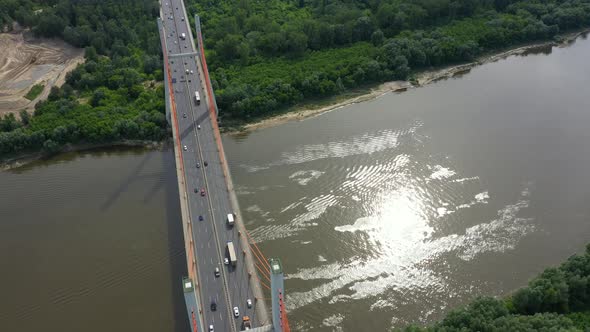 Aerial shooting from flying drone car traffic on modern highway bridge over river
