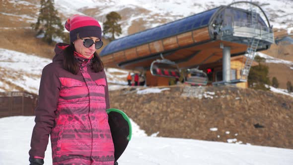 A Young Woman on a Snowboard on Top Mountain on a Ski Track