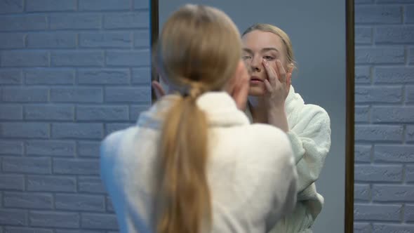 Beautiful Woman in Bathrobe Applying Moisturizing Face Cream, Natural Beauty