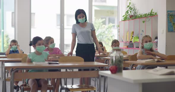 Female Teacher Wearing Face Mask at School Teaching Children at School Classroom