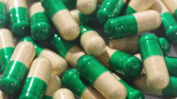 Rotating Yellowgreen Medicine Pills and Capsules