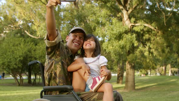 Happy Military Dad in Wheelchair and Daughter Taking Selfie