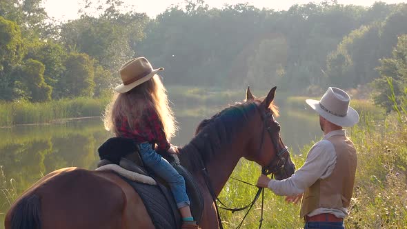 Cowboy and His Daughter on Horseback