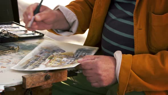 Shot of artist painting using watercolors a scene in Venice.