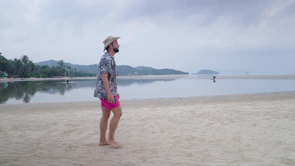 Hipster Bearded Man in 30s Walking on Island Beach in Thailand on Gloomy Day  Slow Motion