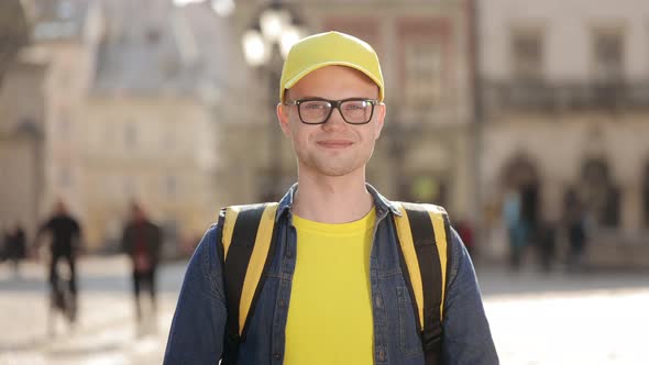 Portrait of a Young Delivery Man Who is Standing and Smiling