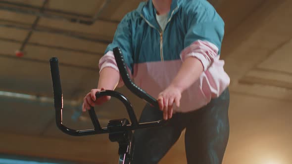 Healthy Caucasian Woman Exercising Workout on Stationary Cycling Machine Bike in Gym Slow Motion