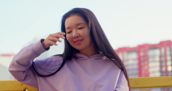 Asian Woman in Sportswear Using Smartphone Outdoors