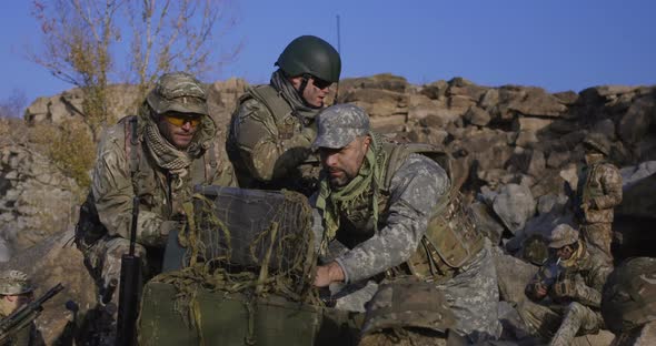 Armed Soldiers Looking at a Computer alt