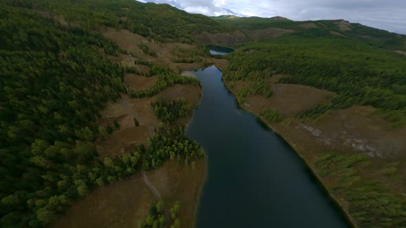 FPV Sport Drone Shot Flying Over Three Mountain Lakes to Spruce Forest and Cliff