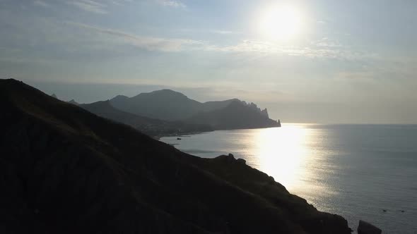 Flight Over the Sea and Mountains at Sunrise. Aerial View of Kara-Dag Mountain in Crimea.