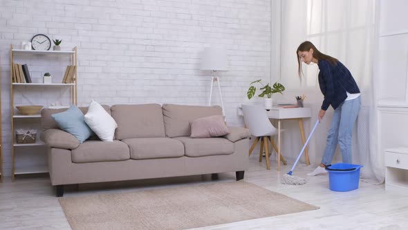 Young Woman Mopping Floor at Home Using Mop and Bucket Slow Motion