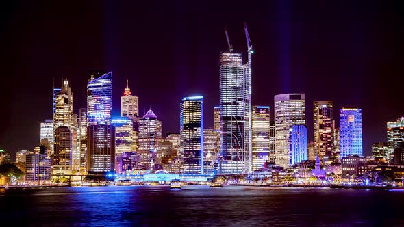 Wide shot of city Skyline with boats passing during Vivid Light festival 2022 Sydney Australia, Mils