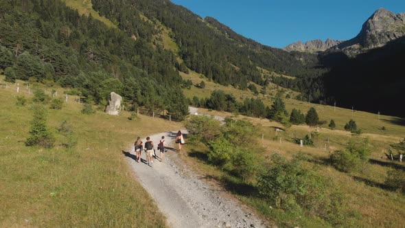 Aerial drone shot of teen friends walking through a mountain path. Pyrenees, Val d'Aran.