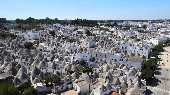 Aerial drone shot of beautiful small town Alberobello, Italy. whitewashed stone huts with conical ro