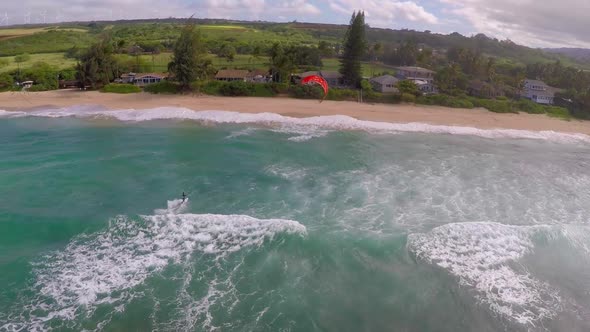 Aerial view of a man kitesurfing in Hawaii.