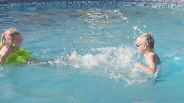 Little Boy and Girl Swimming in Swimming Pool Children Having Fun Splashing Water