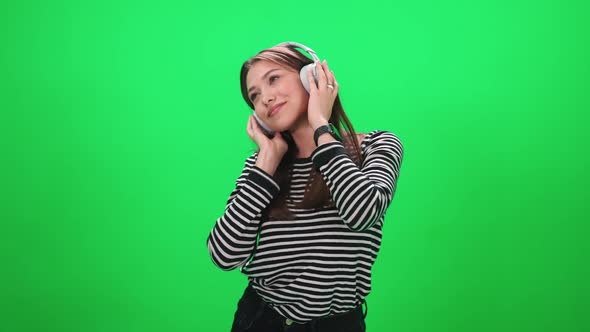 Portrait of a Young Female a Woman Music Lover Listens to Music in Wireless Headphones and Dances