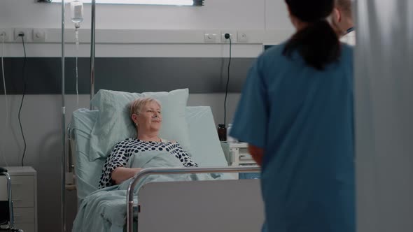 Doctor and Nurse Visiting Patient with Illness in Hospital Ward