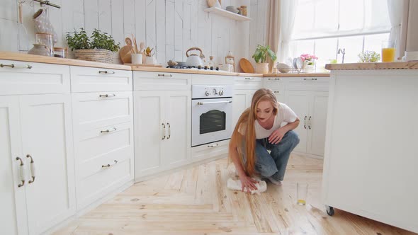 Adult Woman Housewife Blonde with Long Hair Washes Floor in Kitchen Room Wipes Wet Stain on Parquet