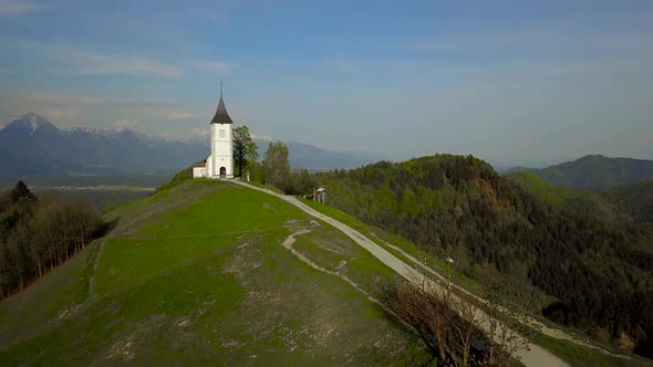 drone footage sunset at Church of St. Primus and Felician, Jamnik, Slovenia 