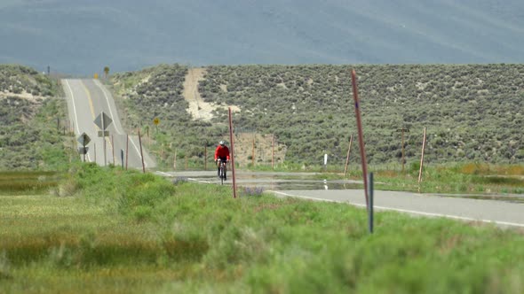 A man road biking on a scenic road.