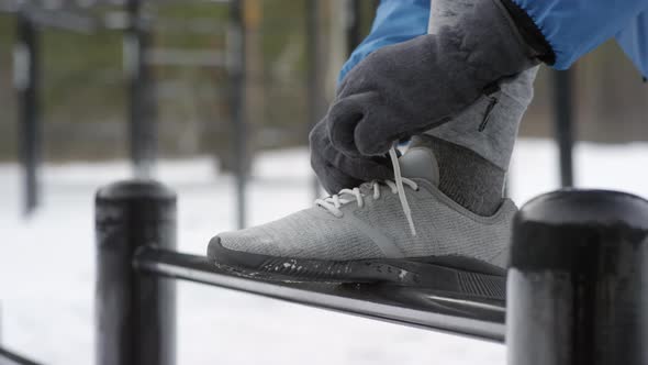 Male Hands Tying Shoelaces Outdoors in Winter