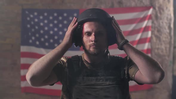 Proud Injured Soldier in Helmet Against US Flag