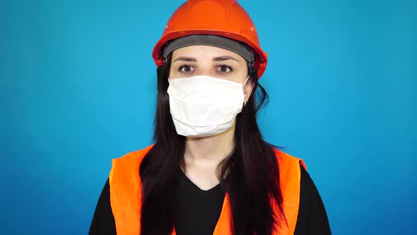 Portrait of Young Woman in Medical Mask on Her Face on Blue Background