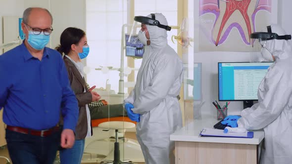 Dentist Doctor with Overall Explaining Teeth Treatment to Patient