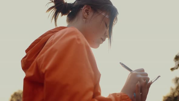 The Young Woman Filmed in Profile Making Notes Writes Something Interesting in Her Notebook