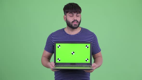 Happy Young Overweight Bearded Indian Man Showing Laptop