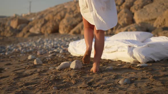 Slim Female Caucasian Legs Walking in Slow Motion to Cushioned Bed on Sandy Beach and Young