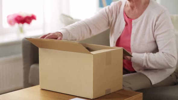 Senior Woman Opening Parcel Box at Home 80