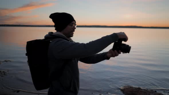 Photographer and Man Model Silhouette Taking Photos at the Lake Shore on Colourful Sunset Slowmotion