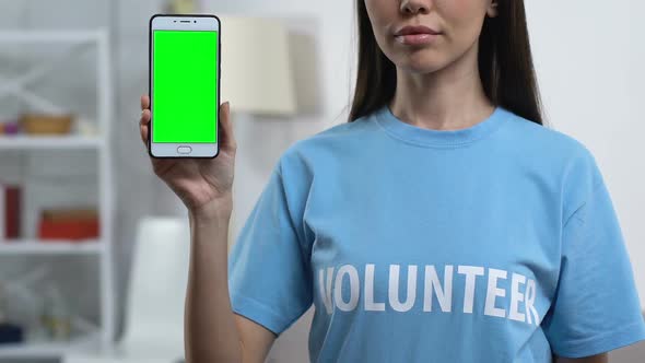 Lady Volunteer Demonstrating Prekeyed Smartphone to Camera, Charity Application