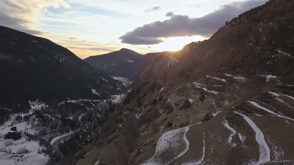 Smooth orbit drone in the Tarter valley to Andorra, in the golden hour, with the sky full of clouds