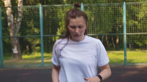 Woman Actively Runs in Place on the Basketball Court Morning Exercises