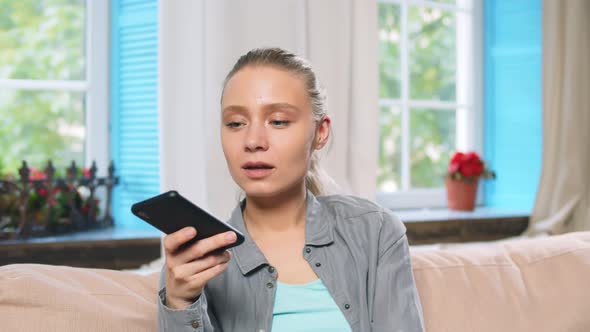 Smiling Young Woman Using Phone Recording Voice Message