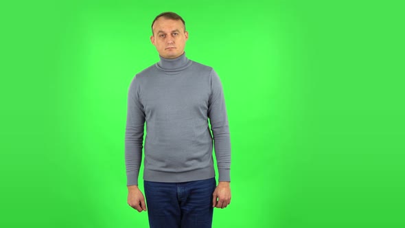 Male Listening Attentively and Nodding His Head Pointing Finger at Viewer. Green Screen