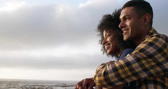 Couple embracing and pointing something with finger at beach 4k