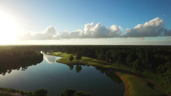 Early morning golf course with blue skies and cloud reflections in the water