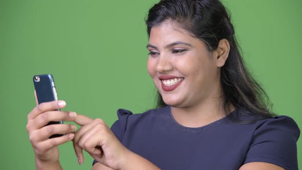 Young Overweight Beautiful Indian Businesswoman Against Green Background