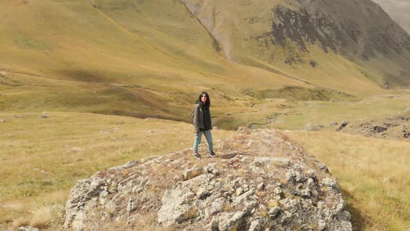 Attractive Girl Stands On Rock Excited 